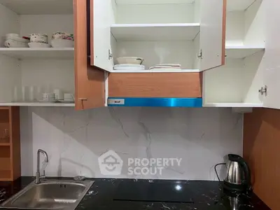 Modern kitchen with sleek cabinets, induction cooktop, and stainless steel sink.