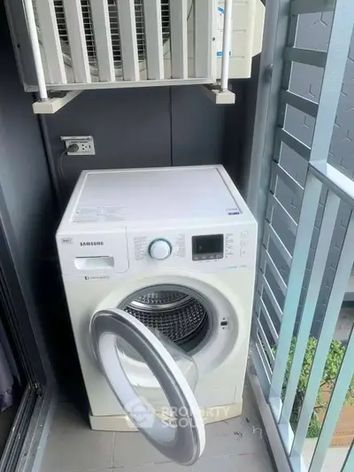 Modern washing machine on a compact balcony with sleek railing design.