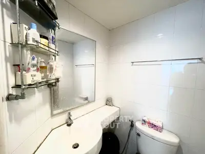 Compact bathroom with modern fixtures and wall-mounted storage shelves.