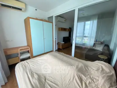 Spacious bedroom with modern furniture and large glass doors leading to a cozy living area.