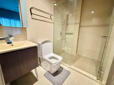 Modern bathroom with glass shower and sleek fixtures in contemporary apartment.
