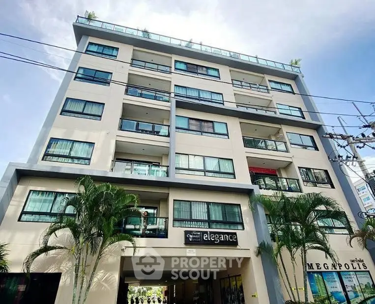 Modern multi-story residential building with balconies and palm trees