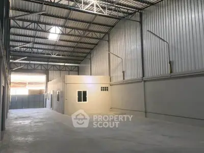Spacious industrial warehouse with high ceilings and ample natural light.