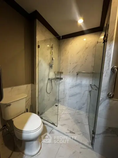 Modern bathroom with glass shower enclosure and elegant marble tiles