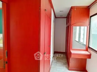 Spacious hallway with built-in wooden storage and large windows