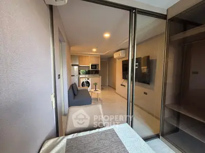 Modern apartment interior with open layout, featuring a cozy living area and kitchen with washing machine.