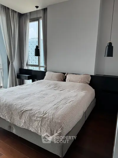 Modern bedroom with large windows and stylish pendant lights in a high-rise apartment.