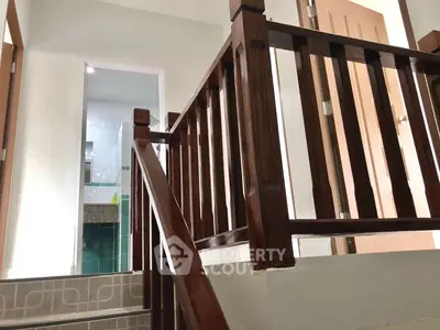 Stylish wooden staircase leading to a modern bathroom with sleek fixtures.