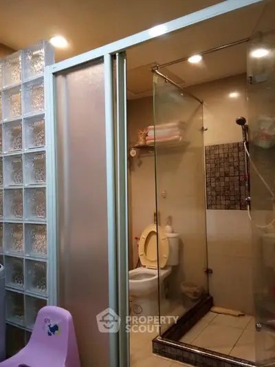 Compact bathroom with glass shower enclosure and modern fixtures, offering a functional and space-efficient interior design.