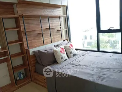 Modern bedroom with stylish wooden shelving and large window offering natural light.