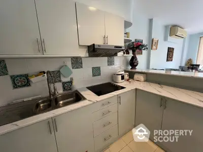 Modern kitchen with sleek cabinetry and marble countertops in a stylish apartment.