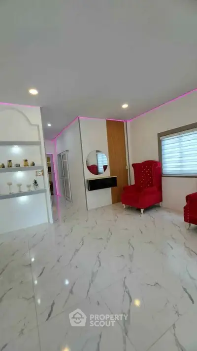 Modern living room with marble flooring, red armchairs, and stylish wall decor.