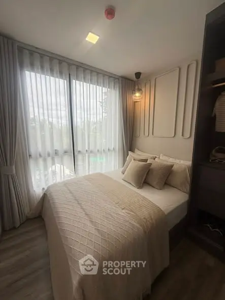 Cozy bedroom with large windows and elegant decor in modern apartment