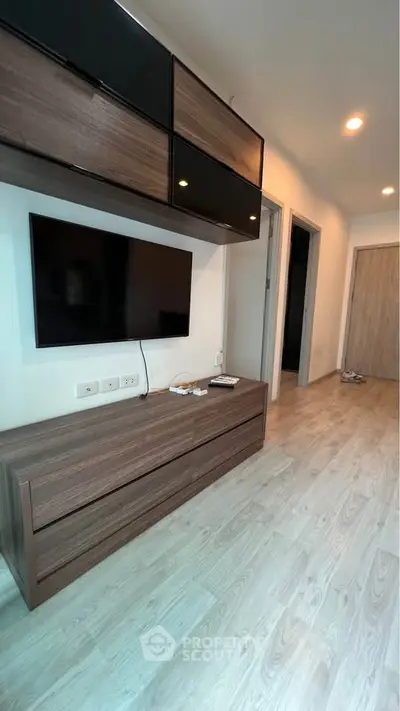 Modern living room with sleek wooden furniture and mounted TV, showcasing contemporary interior design.