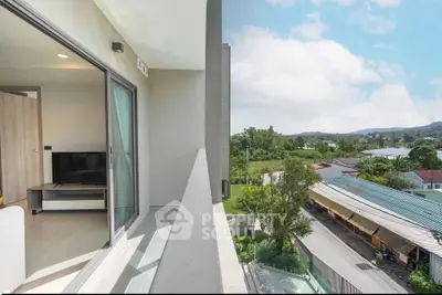 Modern apartment balcony with scenic view of lush greenery and blue sky