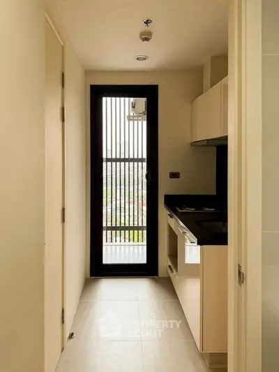 Compact modern kitchen with sleek cabinetry and balcony view