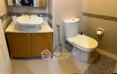 Modern bathroom with stylish sink and toilet in a cozy setting.