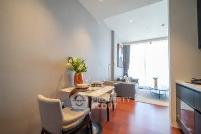 Modern open-plan living room with dining area, featuring elegant decor and natural light.