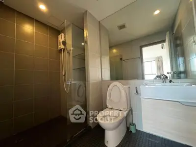Modern bathroom with sleek design and glass shower enclosure in a contemporary apartment.