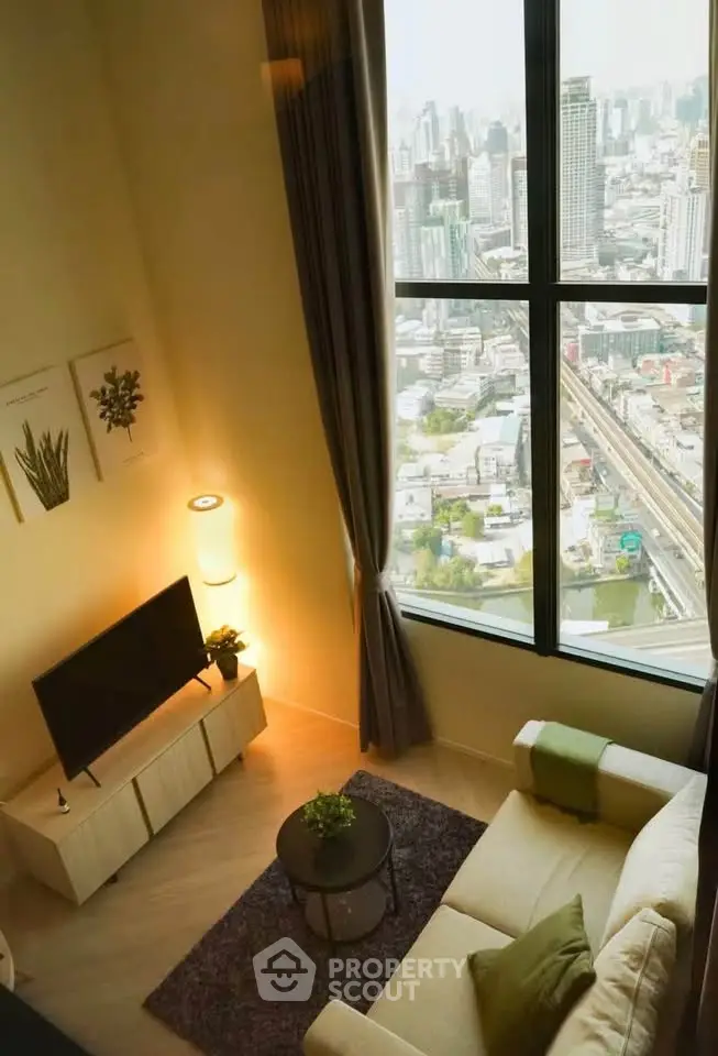 Modern living room with stunning city view from large window, cozy seating, and stylish decor.
