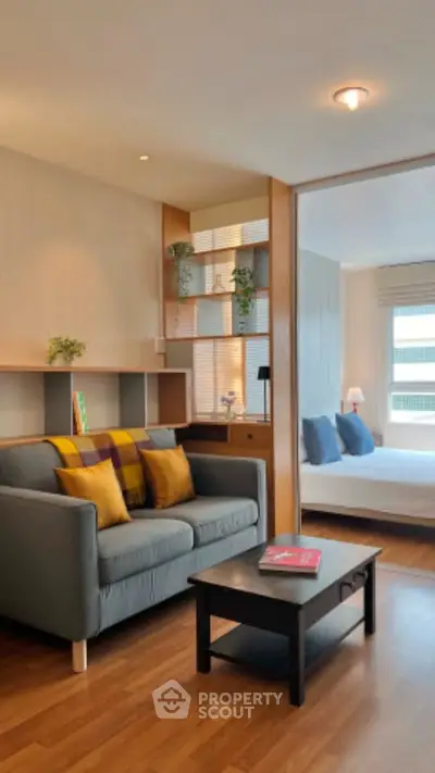 Modern living room with cozy sofa and stylish decor adjacent to a bright bedroom.