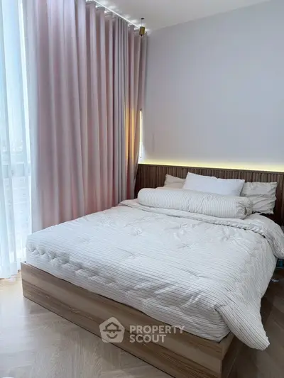 Cozy bedroom with elegant pink curtains and modern lighting, perfect for relaxation.