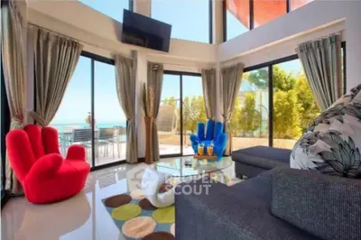 Stunning modern living room with panoramic ocean views and vibrant decor.