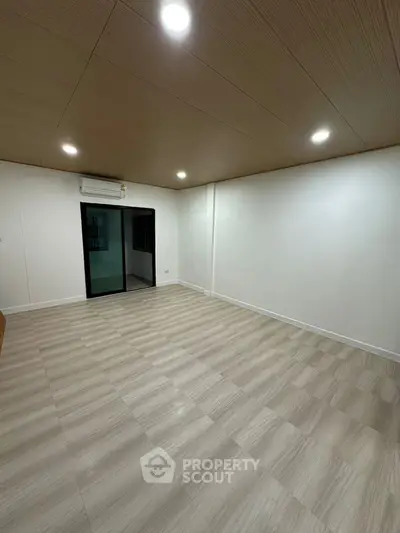 Spacious empty room with modern lighting and air conditioning, ready for customization.