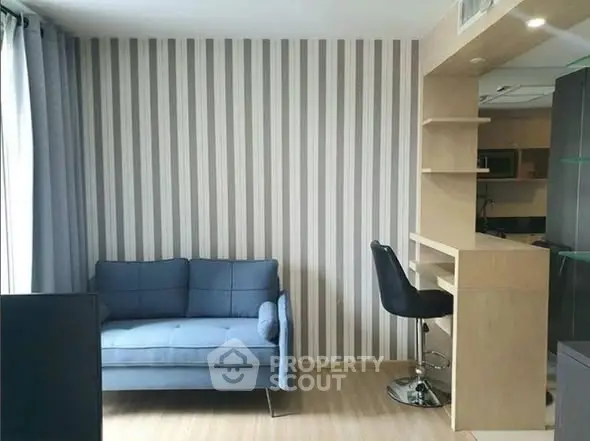 Modern living room with stylish striped wallpaper and cozy blue sofa