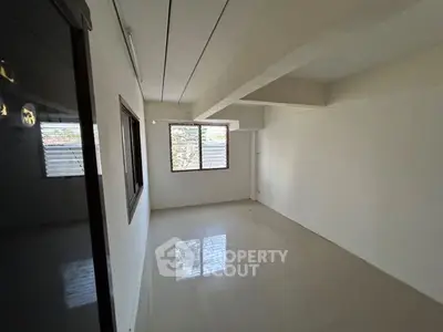 Spacious empty room with large windows and glossy tiled floor, ideal for customization.