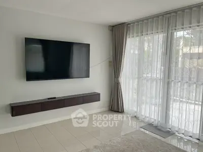 Modern living room with wall-mounted TV and large window drapes