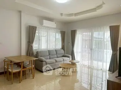 Spacious living room with modern furniture and large windows offering natural light.