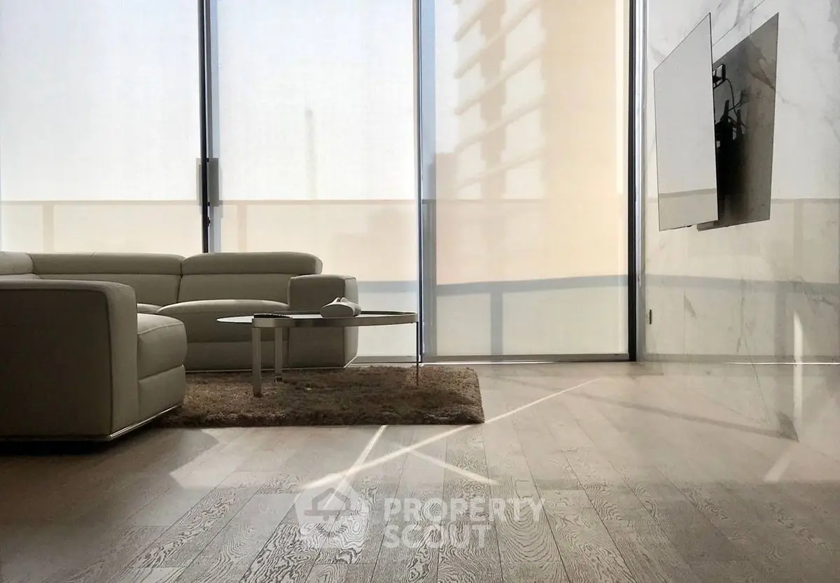 Modern living room with sleek furniture and large windows offering natural light.