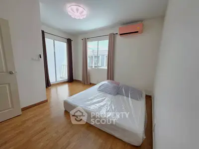 Spacious bedroom with natural light and balcony access in modern apartment