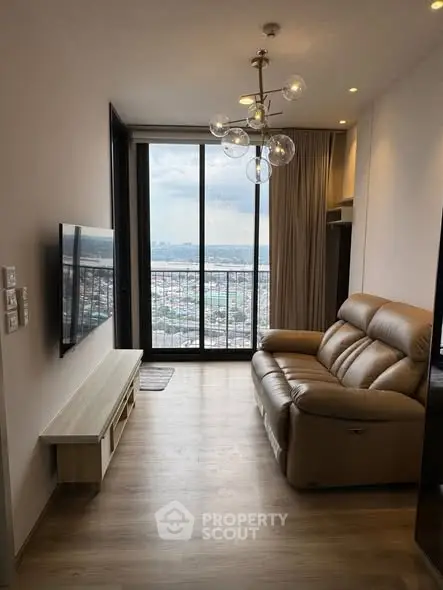 Modern living room with leather sofa and city view from large window.
