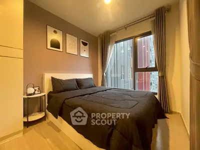 Modern bedroom with stylish decor and large window offering city views, perfect for urban living.