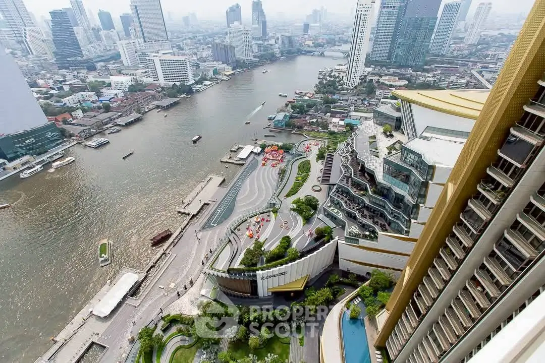 Stunning aerial view of modern riverside cityscape with high-rise buildings and waterfront promenade.