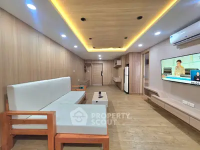 Spacious modern living room with wooden accents and ambient lighting, featuring a sleek TV setup and comfortable seating.