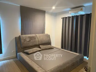 Modern bedroom with stylish bed and air conditioning, featuring elegant gray curtains.