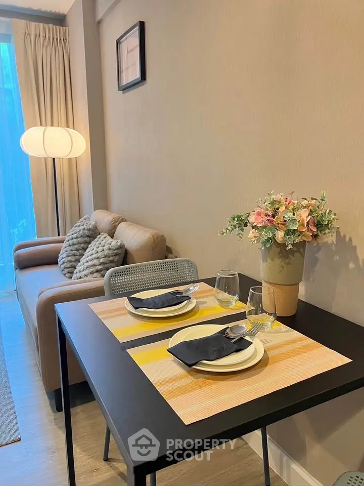 Cozy living room with dining area, featuring elegant decor and natural lighting.