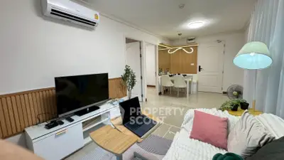 Modern living room with stylish decor, featuring a cozy sofa, TV, and air conditioning, perfect for relaxation.
