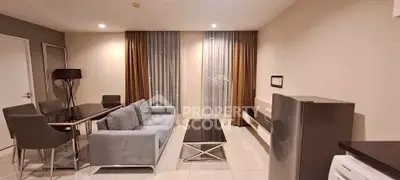 Modern living room with sleek furniture and dining area in a stylish apartment.