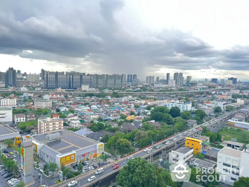 Stunning cityscape view showcasing urban skyline and residential areas under dramatic cloudy sky.