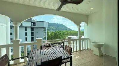 Spacious balcony with stunning mountain view and elegant wooden furniture.