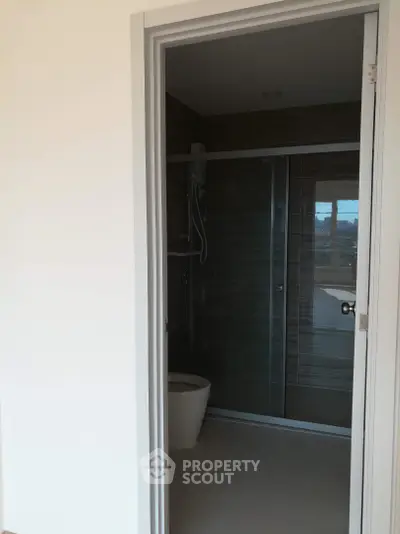 Modern bathroom with sleek glass shower and contemporary fixtures in a stylish apartment.