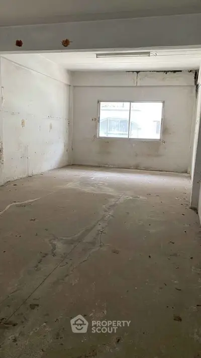 Spacious empty room with large window and natural light, ideal for customization.