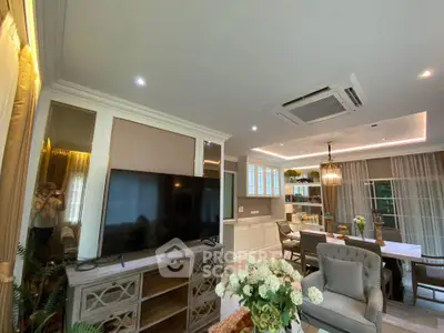Luxurious living room with elegant decor and open dining area, featuring modern lighting and large windows.