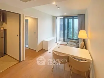 Modern living room with cozy seating and natural light in a stylish apartment.