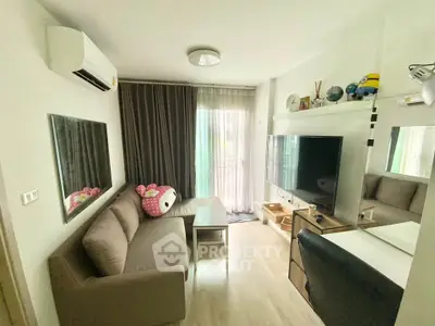 Cozy living room with modern decor, large TV, and plush sofa in a bright apartment.
