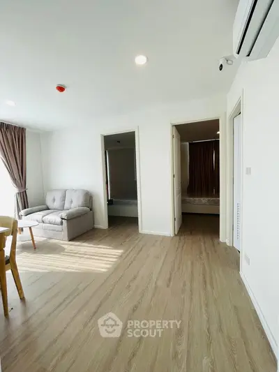 Bright modern living space with wooden flooring and cozy furniture